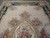 Upper half of the beige field showing floral bouquets, urn motif and shaped green border