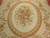 Close-up of the oval center medallion, pink and cream rose bouquet framed by laurel wreath
