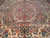 Symmetrical floral drawing in rose, gold and blue across the cream ivory wool pile