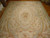 Soft blue and cream Aubusson rug laid on parquet floor showing central rose medallion and scrolls