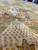 Ivory palmette filled with small gold lattice squares, a signature motif of this Indian rug