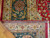 Back of the rug showing tight hand-knotted wool weave and cotton foundation beside green border