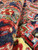 Close-up pile detail of red, navy, olive and ivory hand-spun wool knots, thick dense pile