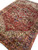 Living room scale view of 10x14 Heriz rug with terracotta field and navy border