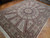 Angled view of the 8x12 wool and silk rug showing paisley panels radiating from center