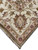 Corner of the ivory wool rug with blush guard stripe, burgundy rosettes and clean fringe