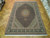8'2" x 12'1" Persian Tabriz rug laid flat on parquet floor showing full medallion layout