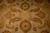 Detail of serrated leaves, rosettes and curling vines across the lustrous beige wool and silk pile
