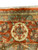 Woven inscription panel in the sage border above a large ivory rosette on coral