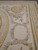 Close corner detail of pink rose cartouche, laurel sprays and layered ribbon border stripes
