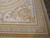 Gold framed floral roundel and acanthus scroll anchoring the corner of this oversize flat weave rug