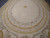Ivory oval medallion field scattered with small gold clover motifs and delicate flower garland