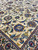 Field detail showing blue and red rosettes, palmettes and curling vine scrollwork on beige ground