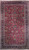 Straight-on full view of burgundy Persian Mashad rug with dense all-over floral field and navy border