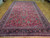 Oversize 9'6" x 16'2" Mashad Persian rug photographed lengthwise, raspberry field with indigo palmette border