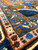 Detail of pink guard stripe and blue floral minor border framing the hand-knotted Heriz design
