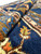 Folded edge of the oversize Persian rug revealing dense wool pile depth and navy field color