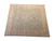 Angled full view of the squarish hand-knotted wool rug in soft sage green and camel