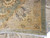 Folded corner close-up revealing dense wool pile, ivory fringe and rust outlined border blossoms