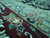 Angled pile view showing rose blossoms, wine border ground and the soft silk sheen in the weave