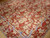 Corner of the oversize 12x18 needlepoint rug with striped ribbon border mitered at the angle