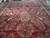 Full length view of the 14x24 oversize wool rug showing symmetrical floral sprays across a wine red field