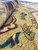 Close-up of camel gold field showing vegetable dyed wool pile with blue and rust motifs