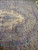 Upper corner of the rug showing lavender scrollwork, green ground and pink floral clusters