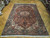 7'10" x 11'3" Persian Heriz rug displayed on parquet floor showing full geometric medallion layout