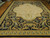 12' x 15' Aubusson area rug seen from one end, gold acanthus border and cream medallion