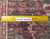 Ruler on rug back showing hand-knotted wool weave density and authentic handmade Persian construction