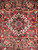 10'2" x 13'5" Heriz rug medallion close-up with ivory latch hooks, indigo rosettes and olive leaves