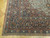 Corner detail showing indigo border, teal guard stripe, ivory rosettes and original selvage binding