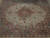 Close overhead detail of the terracotta medallion, arabesque tracery and dense floral wool field