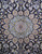 Close-up of the layered starburst medallion in ivory, gold and blue on midnight navy wool
