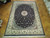 10' x 14'5" Pakistani hand-knotted rug laid flat on parquet floor in showroom