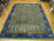 9x12 Chinese Art Deco rug on wood floor, gold inner frame and deep navy floral border