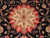 Close-up of the cream and soft green rosette medallion framed by red serrated lobes