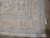 Corner detail showing hand-knotted wool pile, ivory fringe and finely drawn light blue palmette border