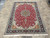 7' x 10' Tabriz wool and silk rug displayed on tile floor with ivory fringe