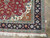 Corner detail showing navy border, apricot spandrel scrollwork and hand-knotted ivory fringe on Persian rug
