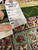 Hand holding authenticity tag marked genuine hand woven oriental rug, number 14871, size 10.7 x 14.6