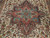 Close-up of teal and brown stepped medallion at the center of the ivory Heriz field