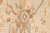 Detail of slate blue rosette with rust vinery and sage leaves on cream wool pile