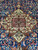 Close-up of terracotta and ivory central medallion with green rosettes on deep navy ground