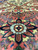 Macro of an 8 petal rosette in navy, aqua and rust on salmon ground