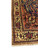 Corner of ivory border with rust shield medallions, navy vinework and cotton fringe end