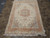 6'7" x 10'2" wool and silk Tabriz rug photographed flat on a tile showroom floor