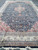 Long vertical view of the navy Kashan design rug showing medallion, pendants and wide ivory border