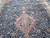 Medallion close-up surrounded by ivory, green and rust flowers on a deep navy blue ground